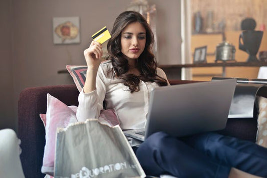 young female trader at laptop with credit card