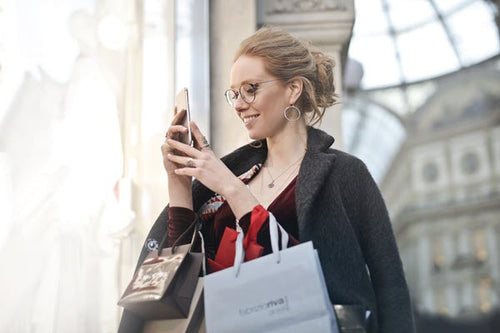 Smiling Shopper Gets Market Update on Smart Phone